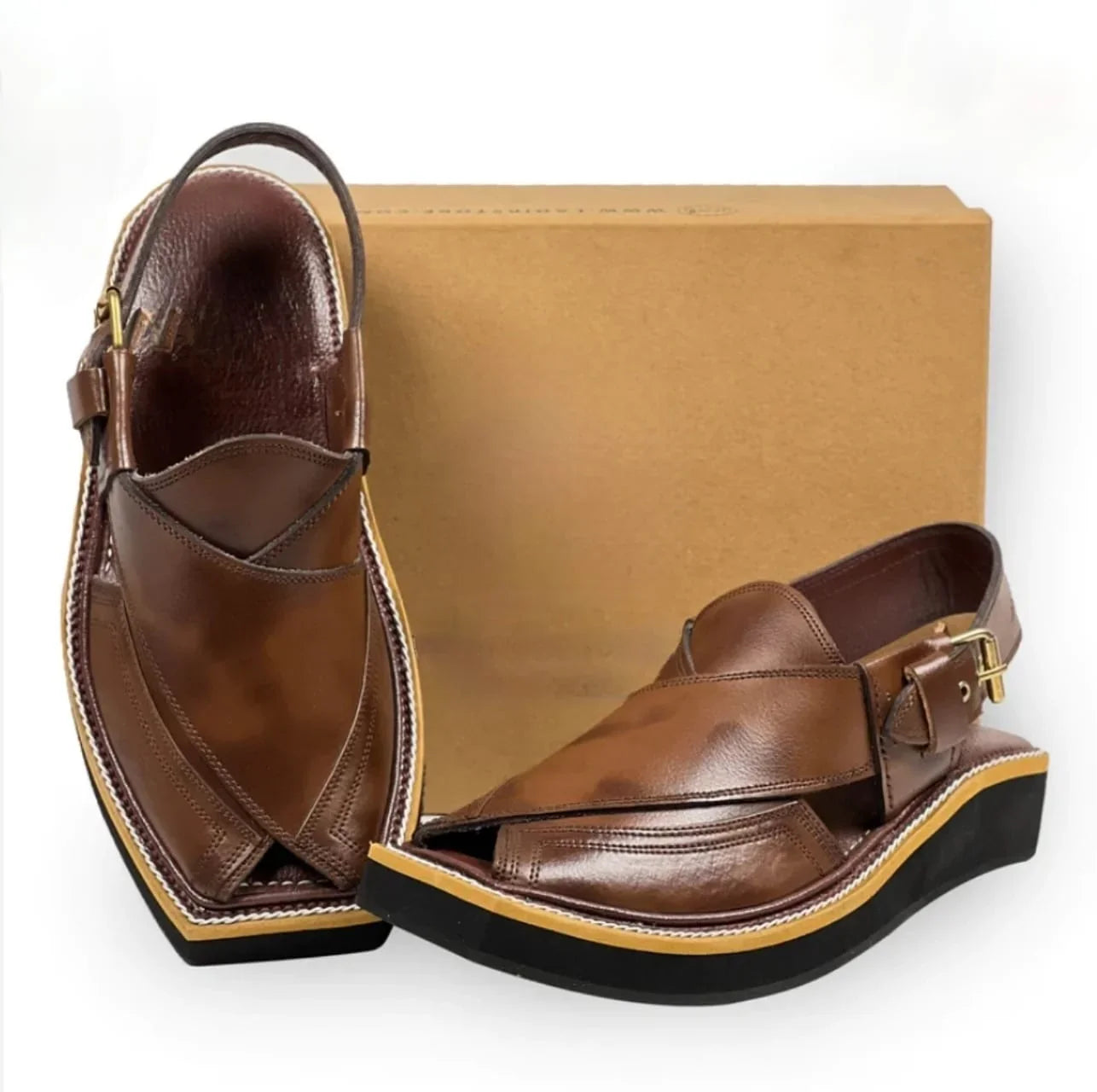 Brown leather Peshawari chappal sandals with black and tan sole beside a plain cardboard box