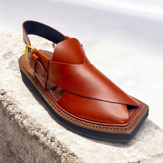 Leather brown men's Peshawari chappal sandal with black sole on stone surface