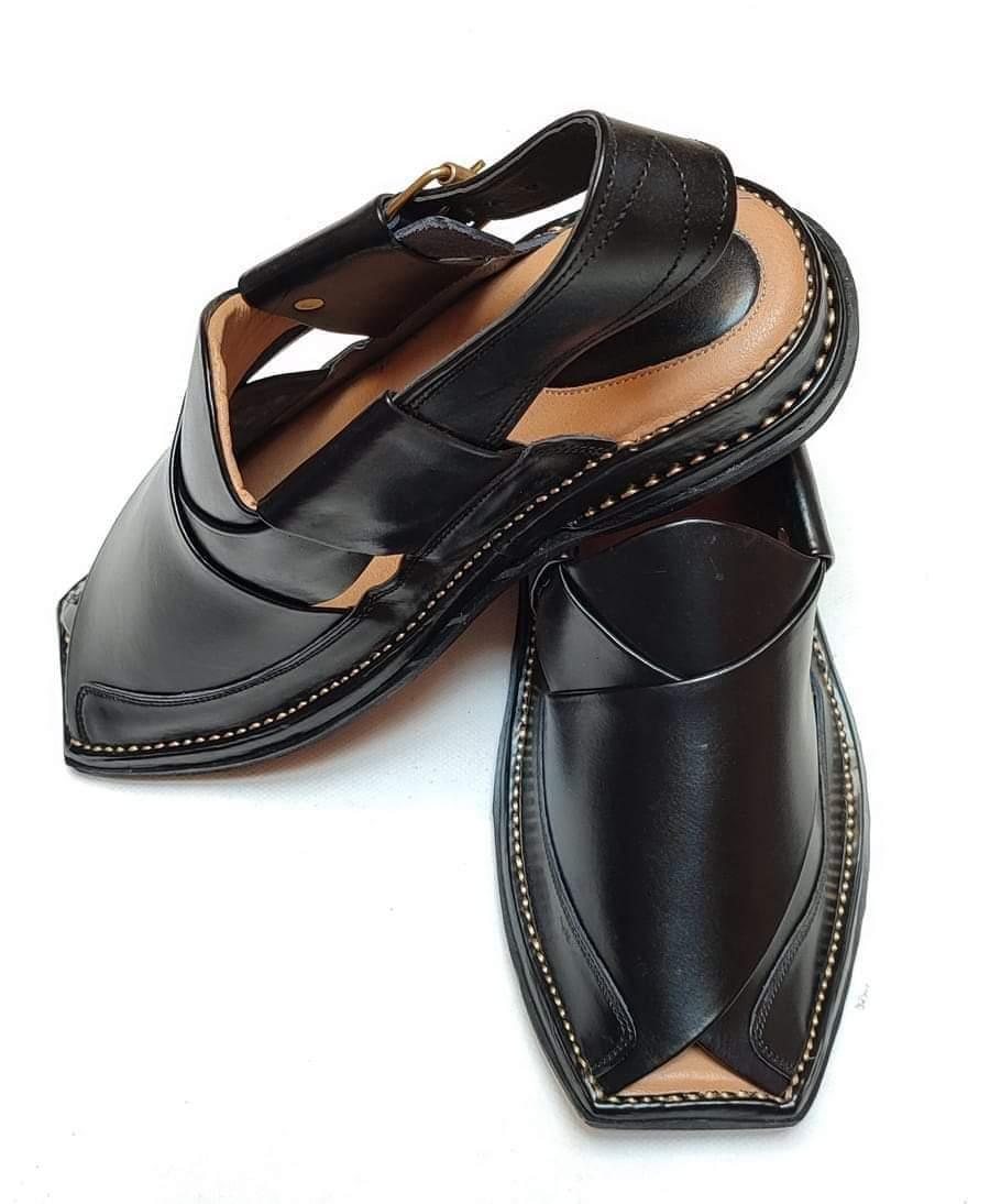 Pair of black leather traditional Peshawari chappal sandals with stitched soles on white background